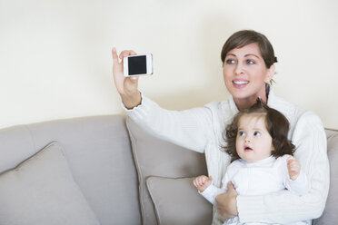 Frau nimmt Selfie mit ihrer Tochter auf Couch - JTLF000062