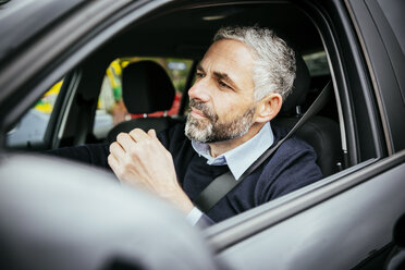 Genervter Mann am Steuer eines Autos - MBEF001320