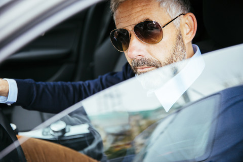 Mann mit Sonnenbrille fährt Auto, lizenzfreies Stockfoto