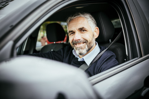 Lächelnder Mann am Steuer eines Autos, lizenzfreies Stockfoto