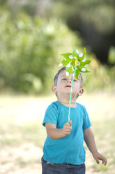 Little boy outdoors playing with paper windmill - ZEF003761