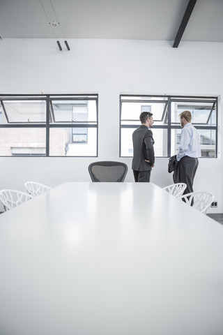 Zwei Geschäftsleute im Büro am Fenster, lizenzfreies Stockfoto
