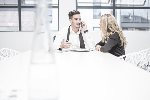 Geschäftsmann und Geschäftsfrau bei einer Bürobesprechung, lizenzfreies Stockfoto