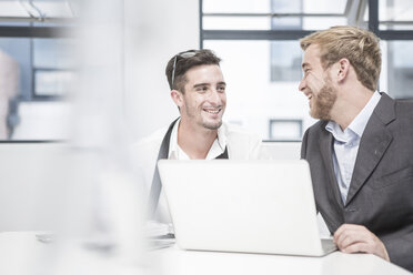 Two smiling businessmen having an office meeting - ZEF004523