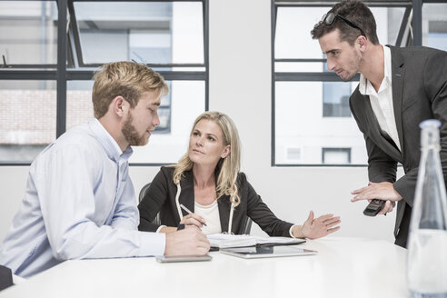 Three businesspeople having an office meeting - ZEF004528