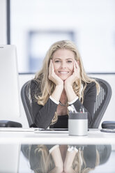 Selbstbewusste Geschäftsfrau sitzt am Schreibtisch - ZEF004577