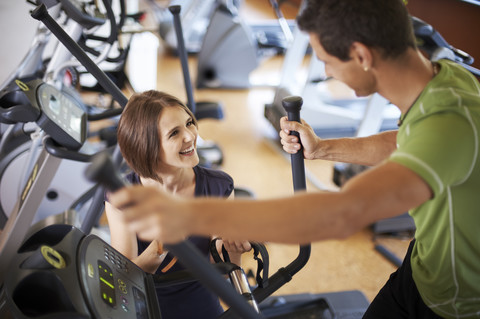 Mann arbeitet mit Trainer im Fitnessstudio, lizenzfreies Stockfoto