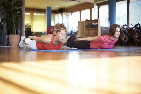 Frau trainiert mit Trainer im Fitnessstudio - MAOF000011