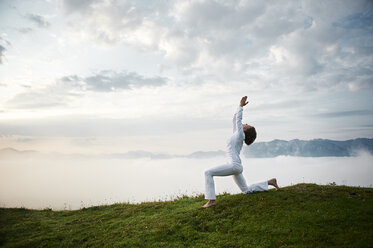 Austria.Kranzhorn, Mid adult woman practising yoga on mountain top - MAOF000015