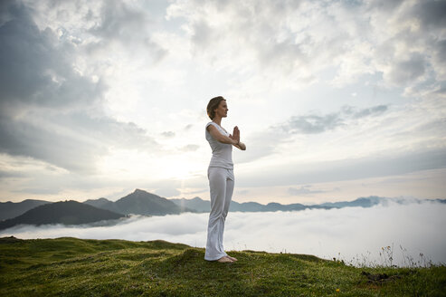 Austria.Kranzhorn, Mid adult woman practising yoga on mountain top - MAOF000016