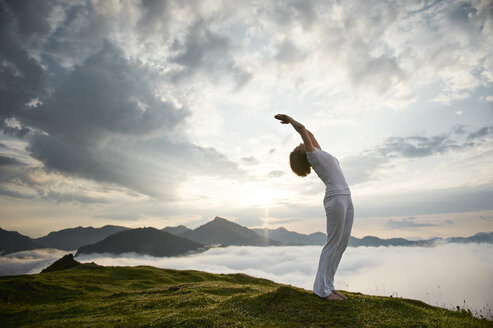 Österreich.Kranzhorn, Mittlere erwachsene Frau übt Yoga auf dem Berggipfel - MAOF000017
