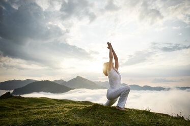 Österreich.Kranzhorn, Mittlere erwachsene Frau übt Yoga auf dem Berggipfel - MAOF000018