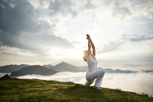 Austria.Kranzhorn, Mid adult woman practising yoga on mountain top - MAOF000018