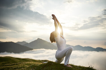 Austria.Kranzhorn, Mid adult woman practising yoga on mountain top - MAOF000019