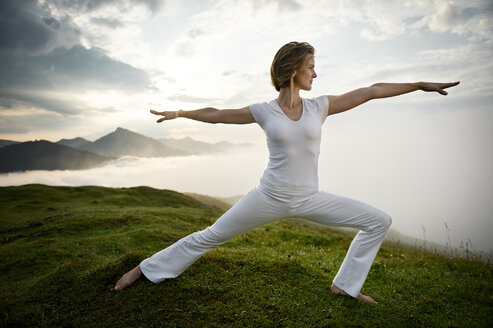 Austria.Kranzhorn, Mid adult woman practising yoga on mountain top - MAOF000021