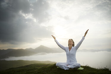 Österreich.Kranzhorn, Mittlere erwachsene Frau übt Yoga auf dem Berggipfel - MAOF000022