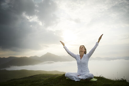 Österreich.Kranzhorn, Mittlere erwachsene Frau übt Yoga auf dem Berggipfel - MAOF000022