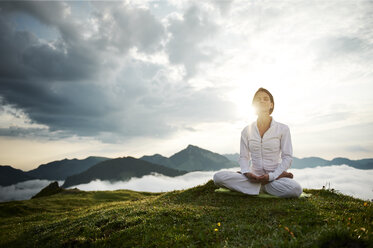 Österreich.Kranzhorn, Mittlere erwachsene Frau übt Yoga auf dem Berggipfel - MAOF000023
