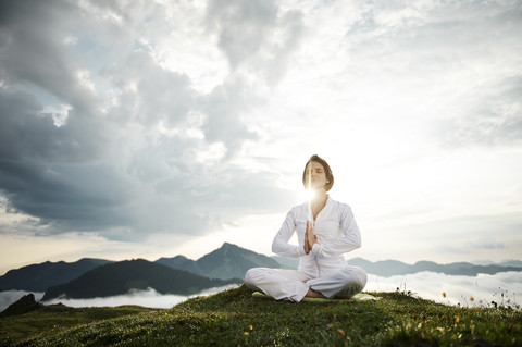 Österreich.Kranzhorn, Mittlere erwachsene Frau übt Yoga auf dem Berggipfel, lizenzfreies Stockfoto