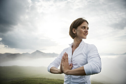 Austria.Kranzhorn, Mid adult woman practising yoga on mountain top - MAOF000029