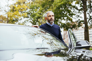 Man standing beside his car - MBEF001333