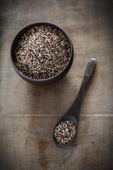 Wooden spoon and bowl of uncooked quinoa tricolor grains - EVGF001367