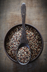 Wooden spoon and bowl of uncooked quinoa tricolor grains - EVGF001368