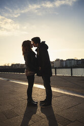 Deutschland, Berlin, jugendliches Paar küsst sich auf einer Promenade am See - MMFF000525