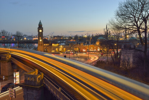 Deutschland, Hamburg, Uhrturm an den Landungsbrücken und Lichtspuren einer U-Bahn bei Sonnenuntergang - RJ000413