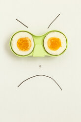 Two halves of an egg in green holder with angry face drawn around it - MELF000050