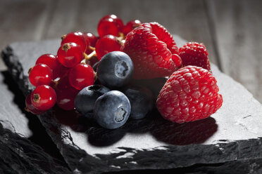 Raspberries, blueberries and red currants on slate - CSF024944