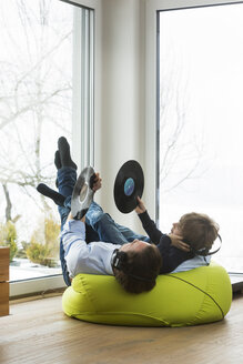 Father and son with records in living room listening music - JTLF000070