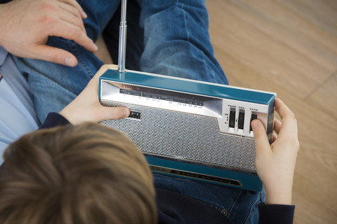 Vater und Sohn hören einem alten Radio zu, lizenzfreies Stockfoto