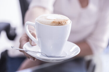 Eine Frau bietet Cappuccino an - ZEF003706