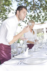 Kellner decken einen Tisch in einem Außenrestaurant ein - ZEF004027