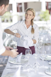Kellner decken einen Tisch in einem Außenrestaurant ein - ZEF004029