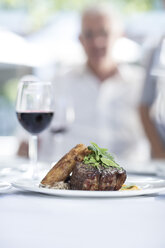 Steak and red wine on table in restaurant - ZEF004092