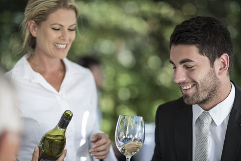 Kellnerin und Kunde mit einem Glas Weißwein - ZEF004158