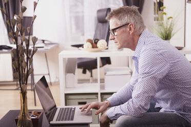 Businessman working with laptop at home office - SEGF000266