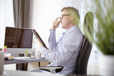 Geschäftsmann bei der Arbeit mit einem digitalen Tablet im Home Office - SEGF000268