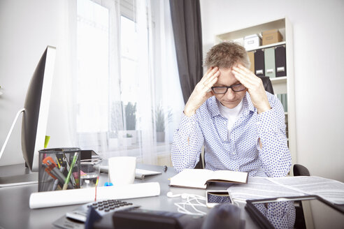 Overstressed businessman at his desk at home office - SEGF000259