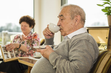 Senior man drinking coffee at home - UUF003558