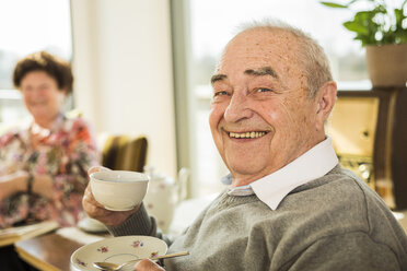 Porträt eines älteren Mannes mit einer Tasse Kaffee zu Hause - UUF003559