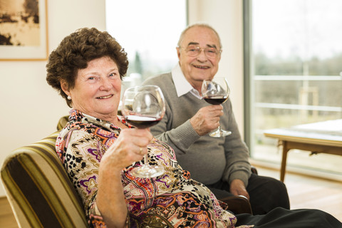 Älteres Paar entspannt sich bei einem Glas Rotwein, lizenzfreies Stockfoto