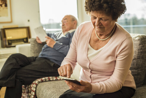 Ältere Frau benutzt Smartphone zu Hause - UUF003608