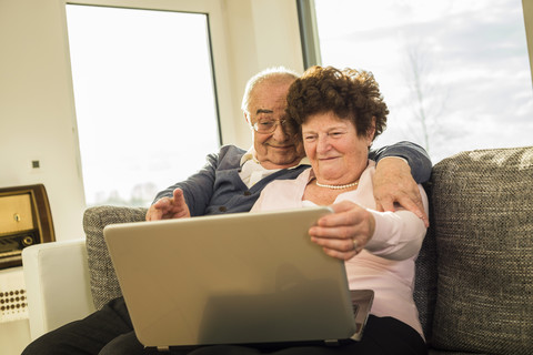 Älteres Paar benutzt Laptop zu Hause, lizenzfreies Stockfoto