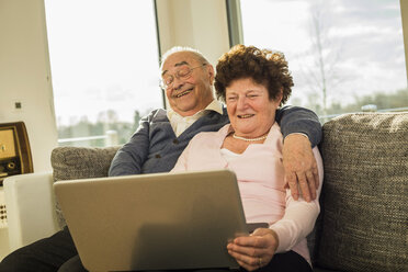 Senior couple using laptop at home - UUF003614
