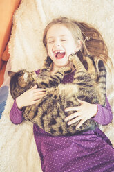 Glückliches Mädchen spielt mit Katze - SARF001509