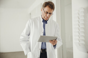 Mature man in lab coat using digital tablet - MFF001519