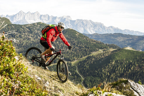 Österreich, Altenmarkt-Zauchensee, junger Mountainbiker beim Fahren in den Niederen Tauern - HHF005292